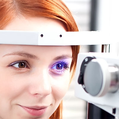 A girl having her eyes examined using an optometrist's slit lamp.