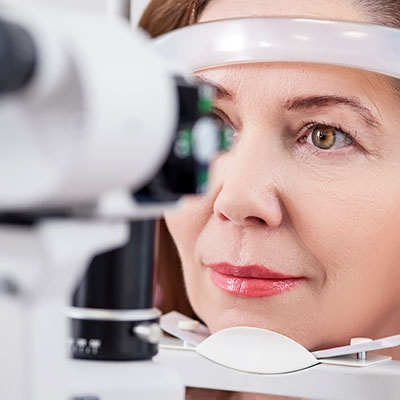 A woman having her eyes examined with a slitlamp during an eye test.